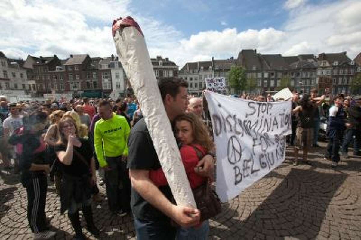 A demonstrator carrying a larger-than-life mock marijuana joint attends a protest rally against the new marijuana buying policy in Maastricht, southern Netherlands, Tuesday May 1, 2012. Weed is technically illegal in the Netherlands, but it is sold openly in small amounts in designated cafes under the country's famed tolerance policy.