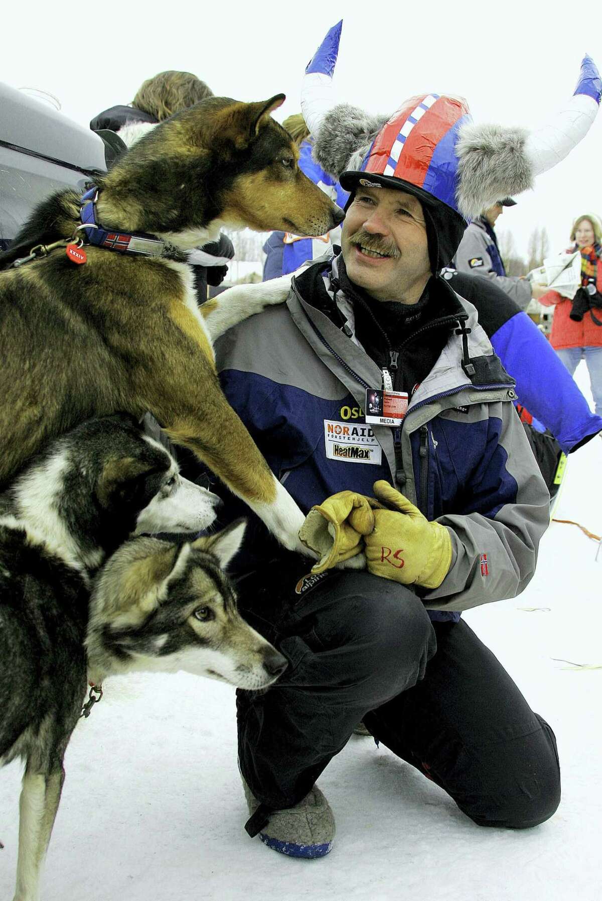 FILE - In this march 5, 2006, file photo, ywo-time Iditarod champion Robert Sorlie, from Norway, plays with Norwegian musher Bjornar Andersen's dogs before the start of the Iditarod Trail Sled Dog Race in Willow, Alaska. An absence of snow, a swan song for two-time champion Robert Sorlie or Norway and Dallas Seavey's bid for a fourth championship in the last five years highlight this year's Iditarod Trail Sled Dog Race. The world's most famous sled dog race starts Saturday in downtown Anchorage with a fan-friendly parade of mushers and their furry teams. (AP Photo/Al Grillo, File)