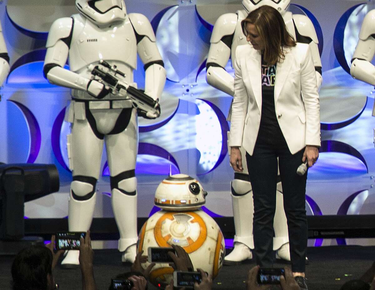 In this April 16, 2015 photo, producer Kathleen Kennedy, right, looks down at the BB-8 droid, featured in the upcoming film, "Star Wars: The Force Awakens," during the Star Wars Celebration at the Anaheim Convention Center in Anaheim, Calif. (Ed Crisostomo/The Orange County Register via AP) MAGS OUT; LOS ANGELES TIMES OUT; MANDATORY CREDIT