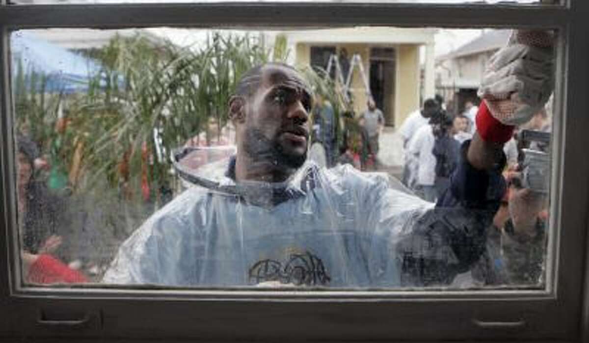 In this Feb. 15, 2008 file photo, NBA basketball player LeBron James scrapes paint from a window in the Lower 9th Ward of New Orleans. This week marks six years since NBA All-Stars ventured into New Orleans neighborhoods devastated by Hurricane Katrina to lend a hand with rebuilding.