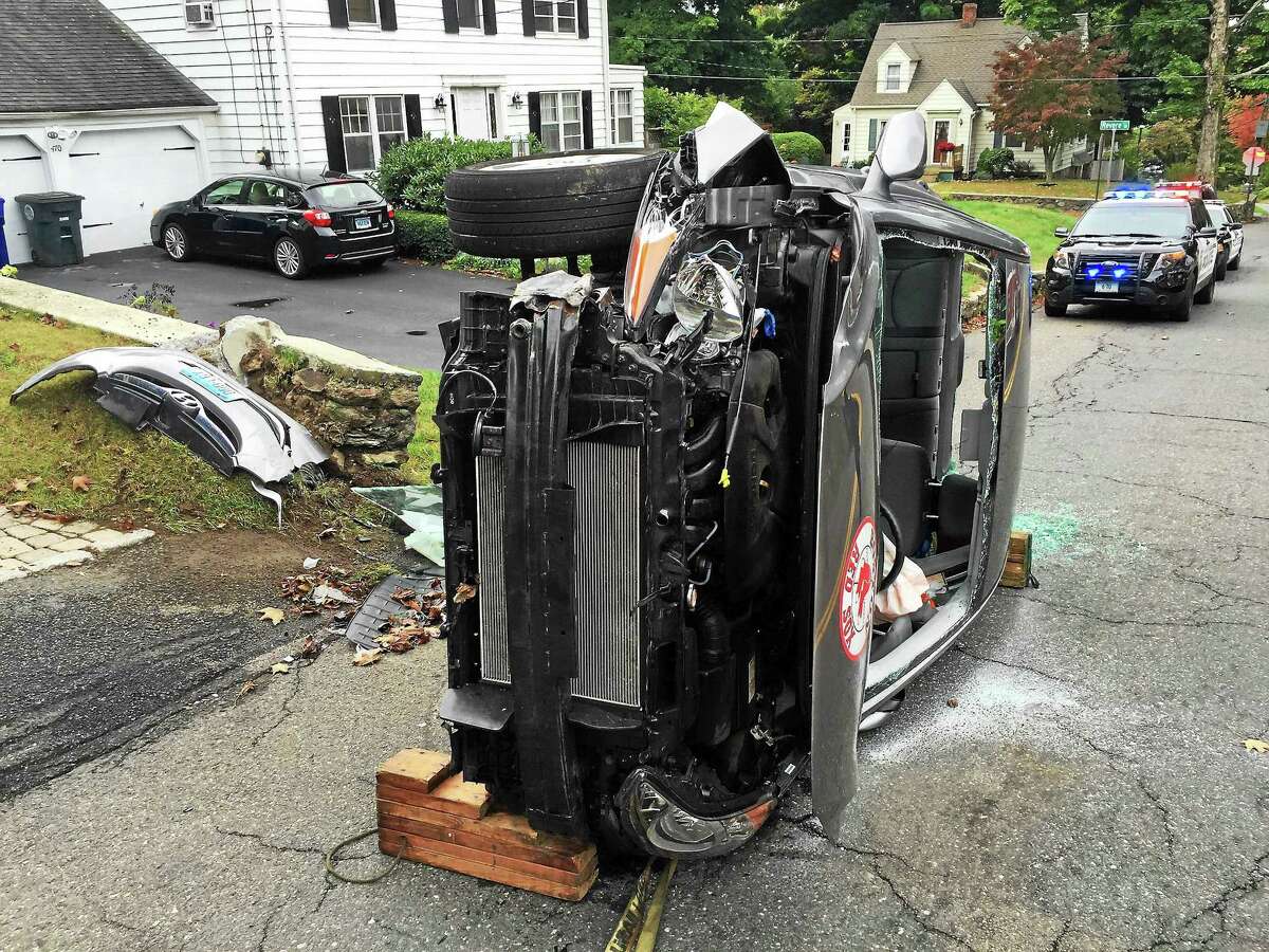 (Ben Lambert - Register Citizen) A woman was rescued after her car flipped over on Charles Street in Torrington early Wednesday afternoon. She suffered minor injuries and the road was closed for a short time.