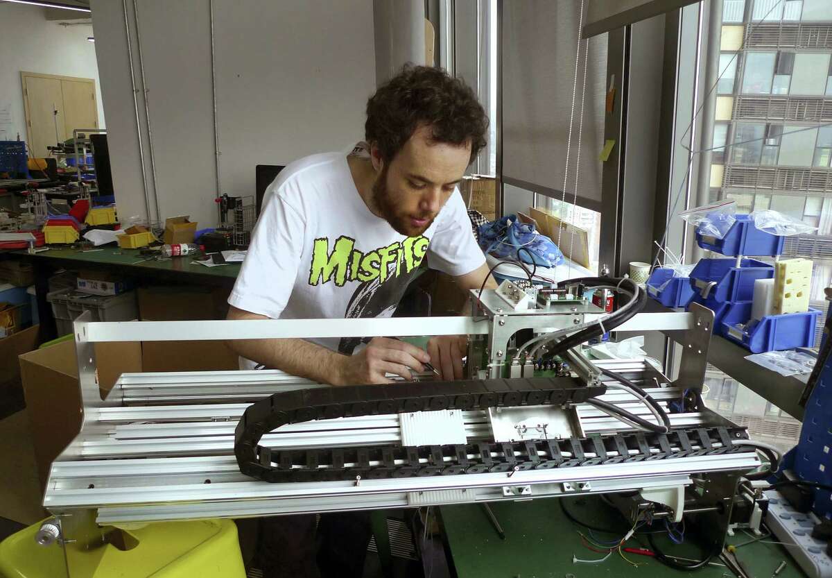 (Kelvin Chan — The Associated Press) Gerard Rubio, CEO of London-based startup Kniterate, works on a prototype for an automated knitting machine his company is developing at the Hax hardware startup “accelerator” in Shenzhen, China.