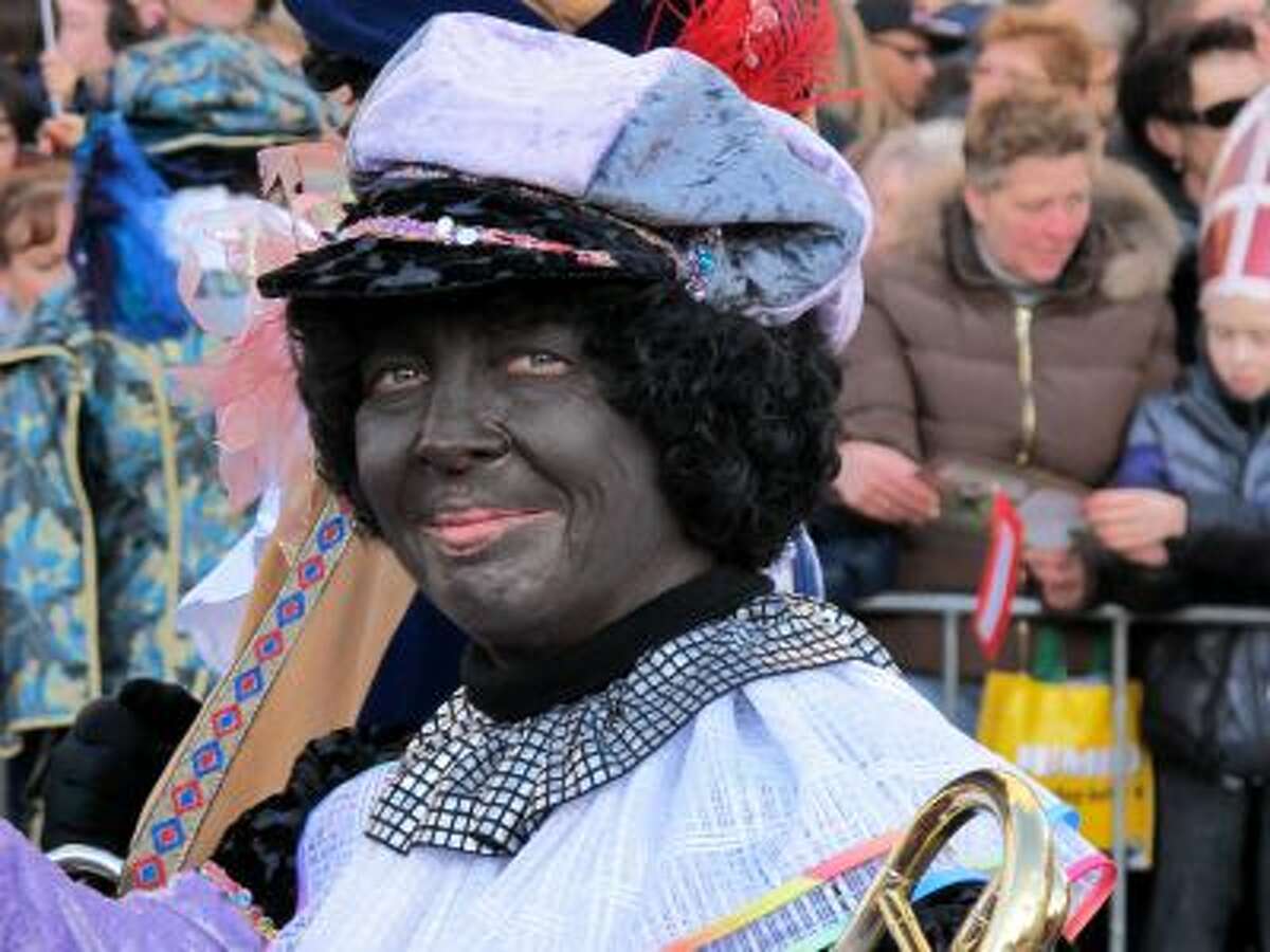 In this Nov. 18, 2012 file photo, a person dressed as "Zwarte Piet" or "Black Pete" attends a parade in Amsterdam, Netherlands.