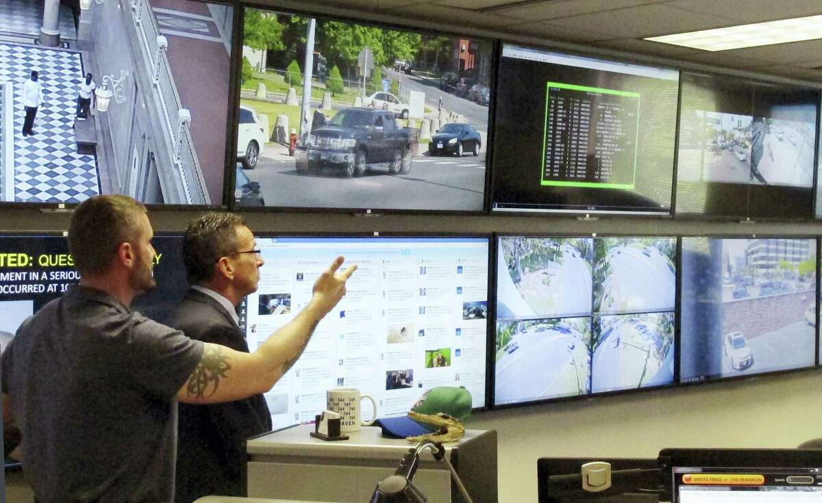 In this Friday, May 20, 2016 photo, Hartford police Sgt. Johnmichael O'Hare, left, shows Connecticut Gov. Dannel P. Malloy the police department's Real-Time Crime and Data Intelligence Center in Hartford, Conn. Staff at the center analyze data from surveillance cameras, gunshot detectors, license plate scanners and other sources. Such facilities are proliferating nationwide with the expanded use of surveillance technology, raising some concerns from civil liberties advocates. (AP Photo/Dave Collins)