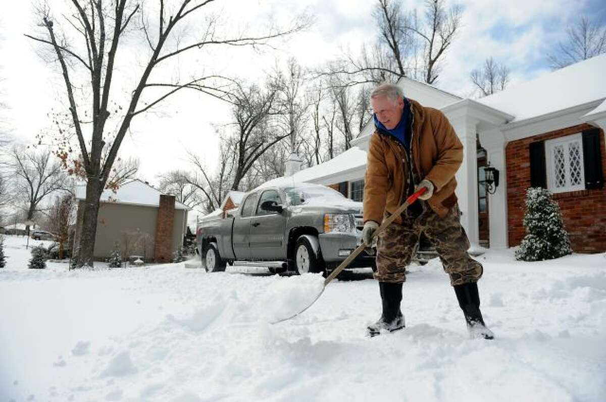 Gary McMillan, 73, of Paducah, Ky., shovels snow at his home in Paducah on Monday, March 3, 2014. A winter storm brought ice, sleet and snow to the region hampering travel and business. Area colleges, school and shopping centers have closed. (AP Photo/Stephen Lance Dennee)