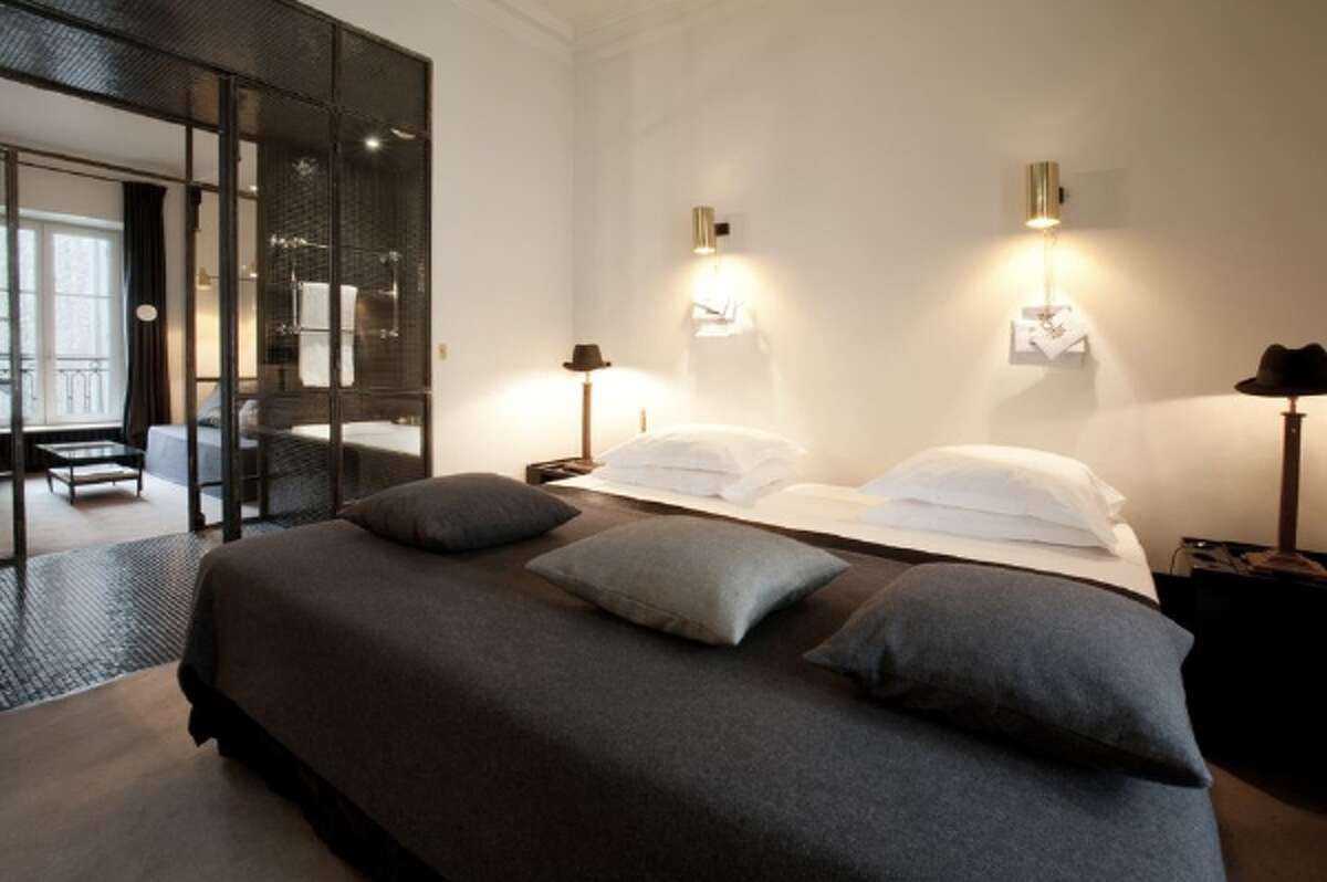 A glass-walled bathroom acts as a room divider between sleeping and lounging spaces at the Hotel Particulier Montmarte in Paris. "I think of bathrooms as living rooms," said Morgane Rousseau, who designed the Hotel Particulier Montmartre. (Morgane Rousseau)