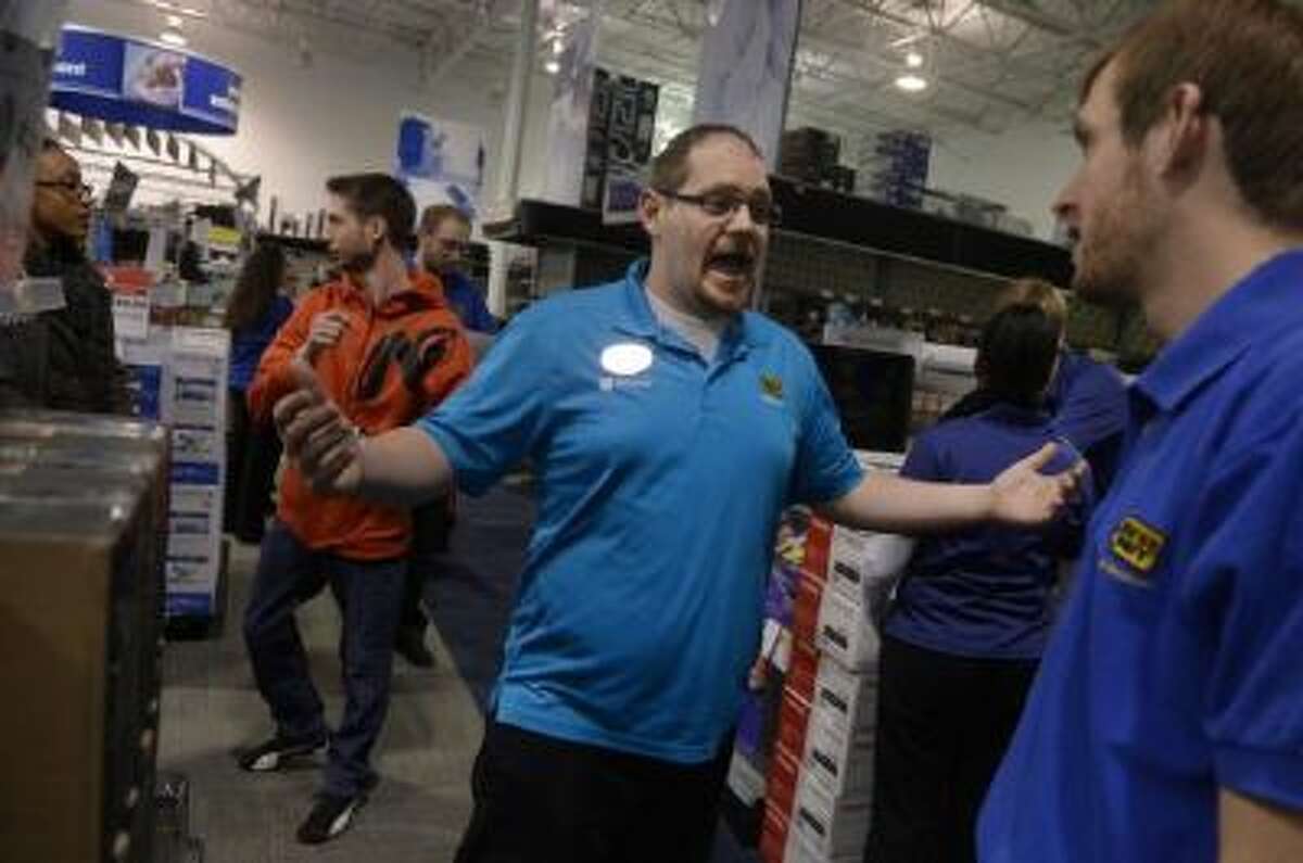 Employee Brent Gill poses a question while playing the part of a customer during a Black Friday rehearsal at a Best Buy store in Denver.