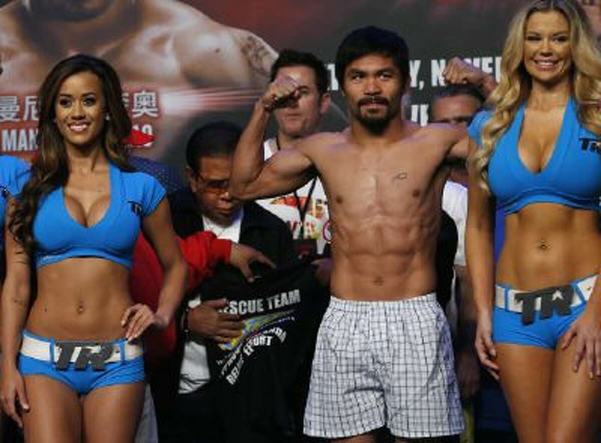 Filipino boxer Manny Pacquiao poses for photos during the weigh-in for his welterweight boxing fight against Brandon Rios of the United States at the Venetian Macao in Macau Saturday, Nov. 23.
