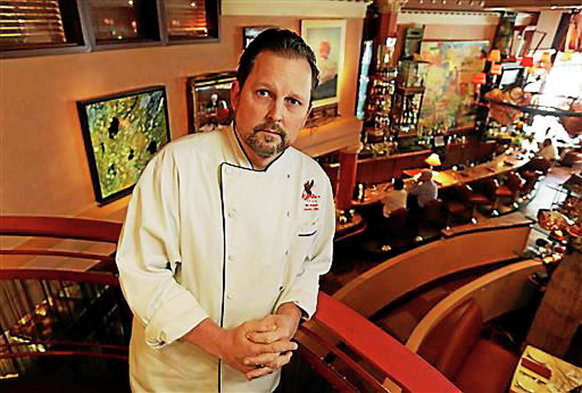 Nick Musser, general manager and executive chef of the icon Grill in Seattle, poses for a photo, Monday, June 2, 2014, in the dining area of his restaurant. Musser is worried that aspects of the $15 minimum wage passed Monday by the Seattle City Council will make it difficult for his independent restaurant to compete with larger companies that also operate restaurants. (AP Photo/Ted S. Warren)