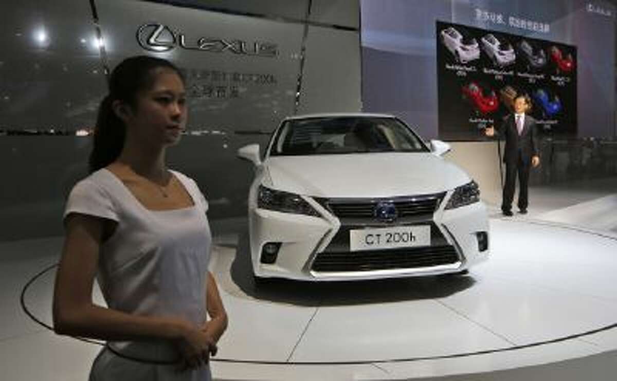 A model stands next to a Lexus CT 200h at the Guangzhou Auto Show Nov. 21.
