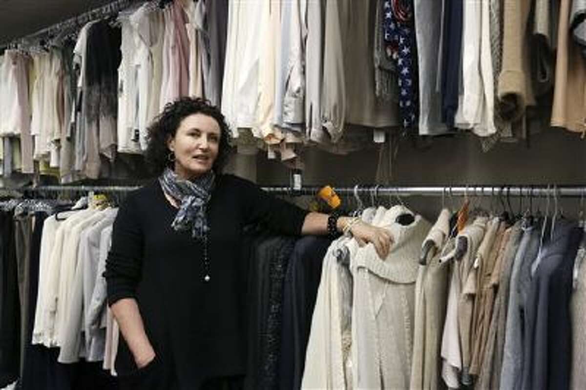 In this Nov. 11, 2013 image released by ABC, costume designer Lyn Paolo stands with costumes for the ABC drama series, "Scandal," in the show's wardrobe closet on the Sunset Gower lot in the Hollywood section of Los Angeles. The series, about a Washington fixer, airs Thursdays at 10 p.m. EST.