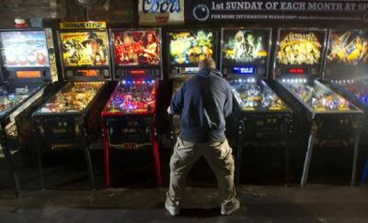 Eric Jablonski of Colorado Springs puts some body language into his pinball as he plays at The 1Up Arcade and Bar in Denver on Wednesday, November 6, 2013.