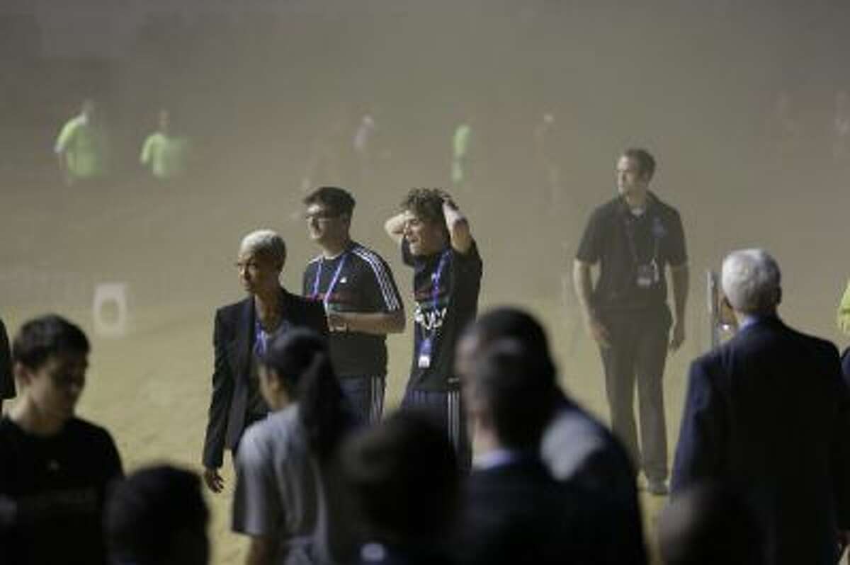 Members of the Minnesota Timberwolves teamm leave as smoke engulfs the basketball court during a regular season NBA match between the Timberwolves and the San Antonio Spurs in Mexico City, Wednesday, Dec. 4, 2013.