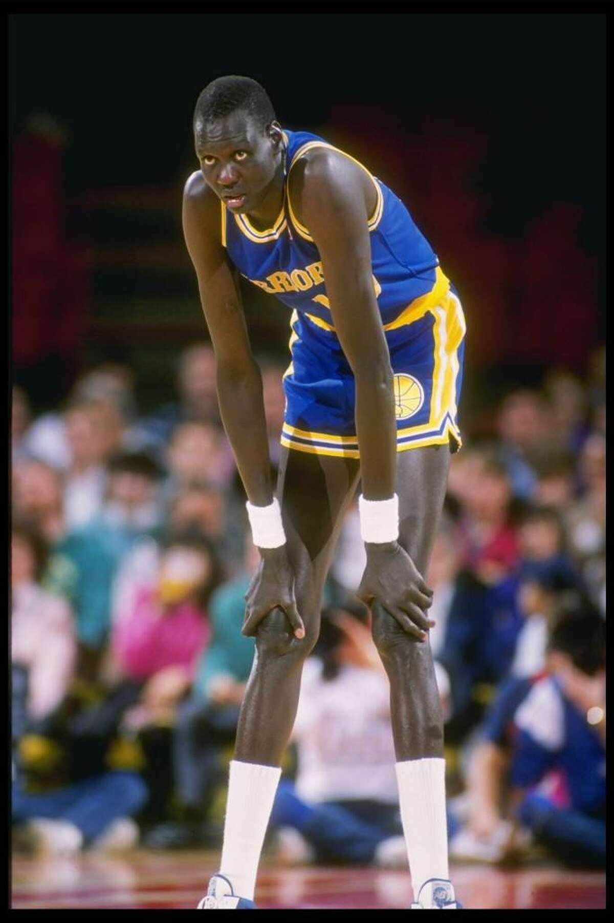 1989-1990: Manute Bol of the Golden State Warriors looks on during a basket...