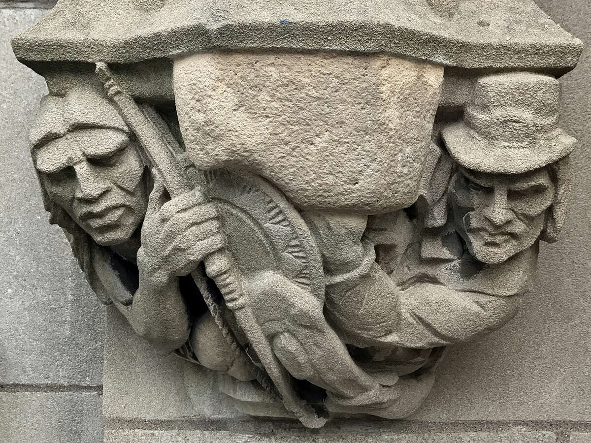 A 1929 doorway carving depicts a Puritan settler, right, pointing a musket at the head of a Native American, left, on the school’s campus in New Haven, but the musket has been covered over by the university.