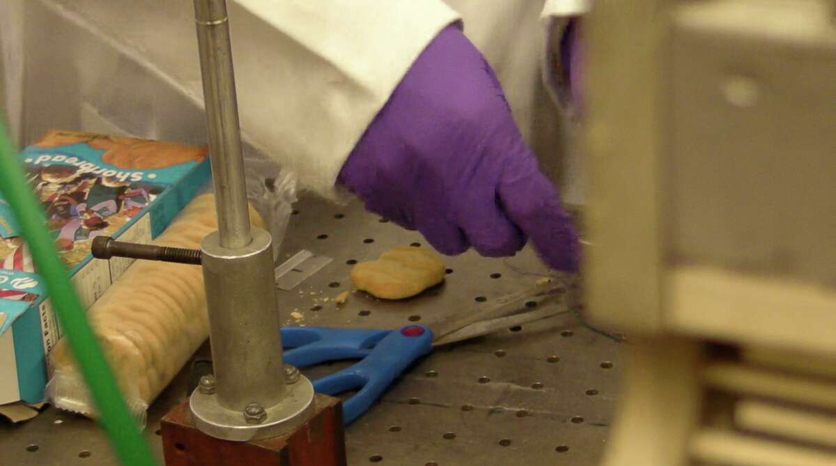 Rice University graduate student Zhengzong Sun prepares a Girl Scout shortbread cookie for the furnace, where carbon from the cookie will turn into a sheet of graphene, the one-atom-thick form of carbon. Students in the Rice lab of chemist James Tour calculated that at then-current rates, a box of cookies could yield $15 billion in graphene, enough to cover nearly three football fields.
