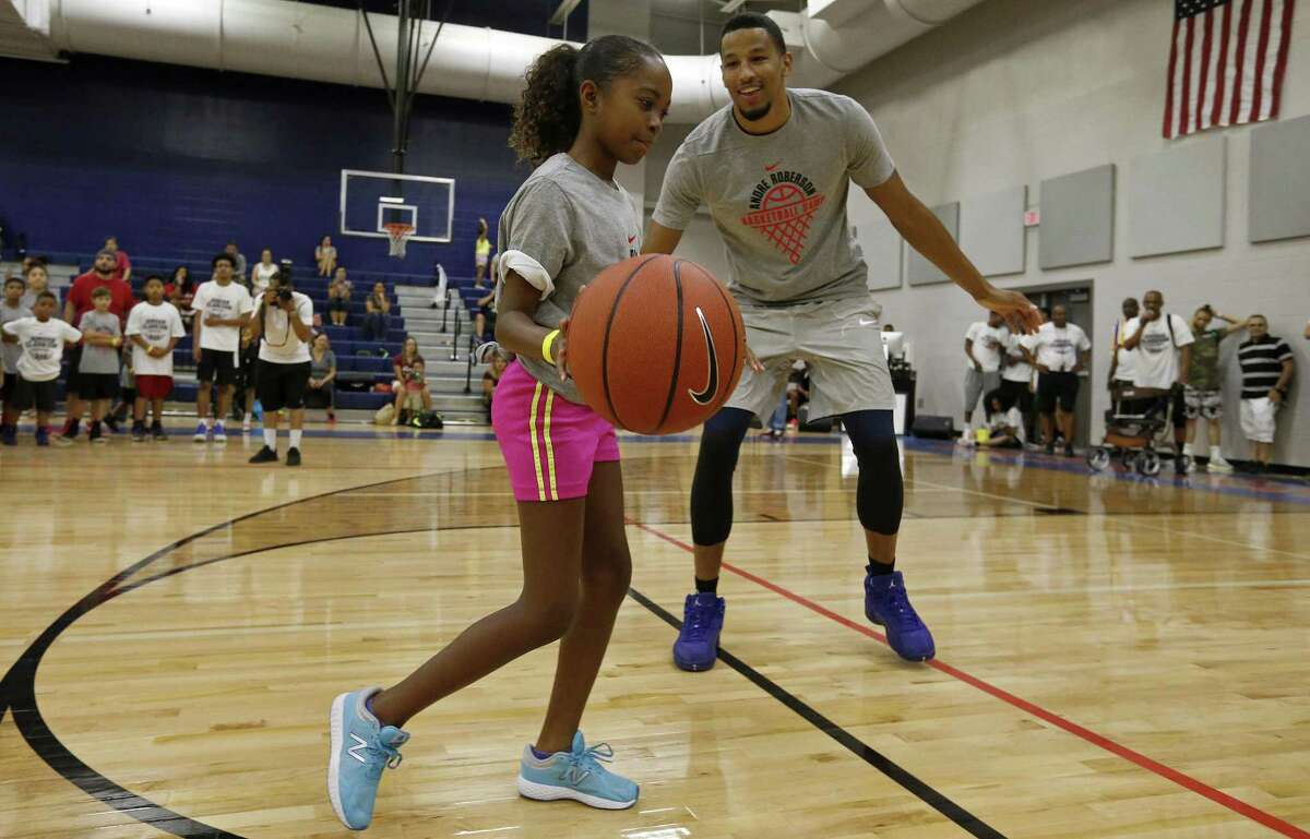 Oklahoma City Thunder’s Andre Roberson defends Sarai Miller, 9, during a dual basketball clinic with Los Angeles Lakers’ Jordan Clarkson (not pictured) on Aug. 4, 2017 at Veterans Memorial High School in San Antonio.