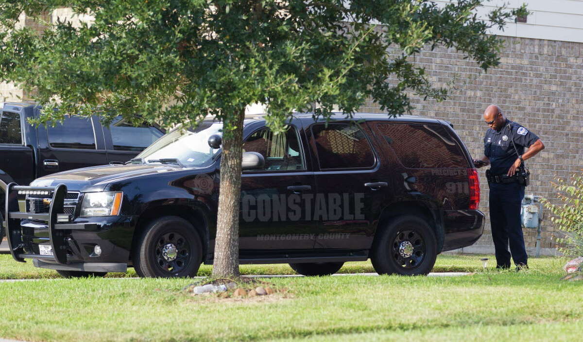 An deputy with the Montgomery County Precinct 3 Constable's Office is seen at a home in the 1600 block of Julia Park Lane where nine children were taken after the mother and father were arrested and charged with child endangerment, Wednesday, Aug. 23, 2017, in Spring. One child was transported to Texas Children?•s Hospital, while the other eight were put into custody of Child Protective Services.
