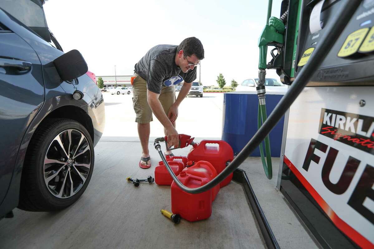Chris Mathew fills his vehicle and five gasoline cans at Costco in preparation for a possible hurricane.﻿