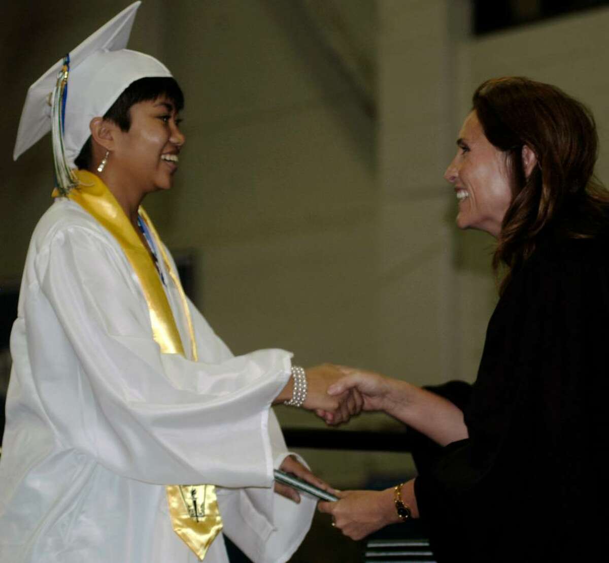 Elizabeth Marandola is a happy graduate as she accepts her diploma Saturday from Board of Education chairman Wendy Faulenbach during New Milford High School's commencement exercises at the O'Neill Center in Danbury.