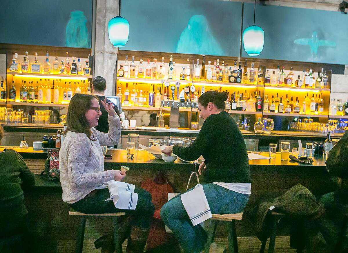 People enjoy cocktails during happy hour in the front bar at Comal restaurant in Berkeley, Calif., on Thursday, January 10th, 2013.