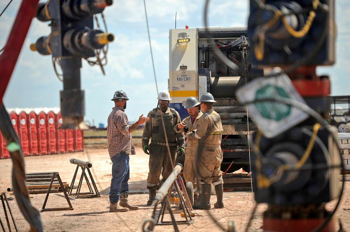 Octane Energy well-site leader Justin "Bull" Smith (left) talks with a GR Energy Services wireline crew at a fracking site managed by Octane Energy on Friday, Sept. 23, 2016 near Stanton. James Durbin/Reporter-Telegram