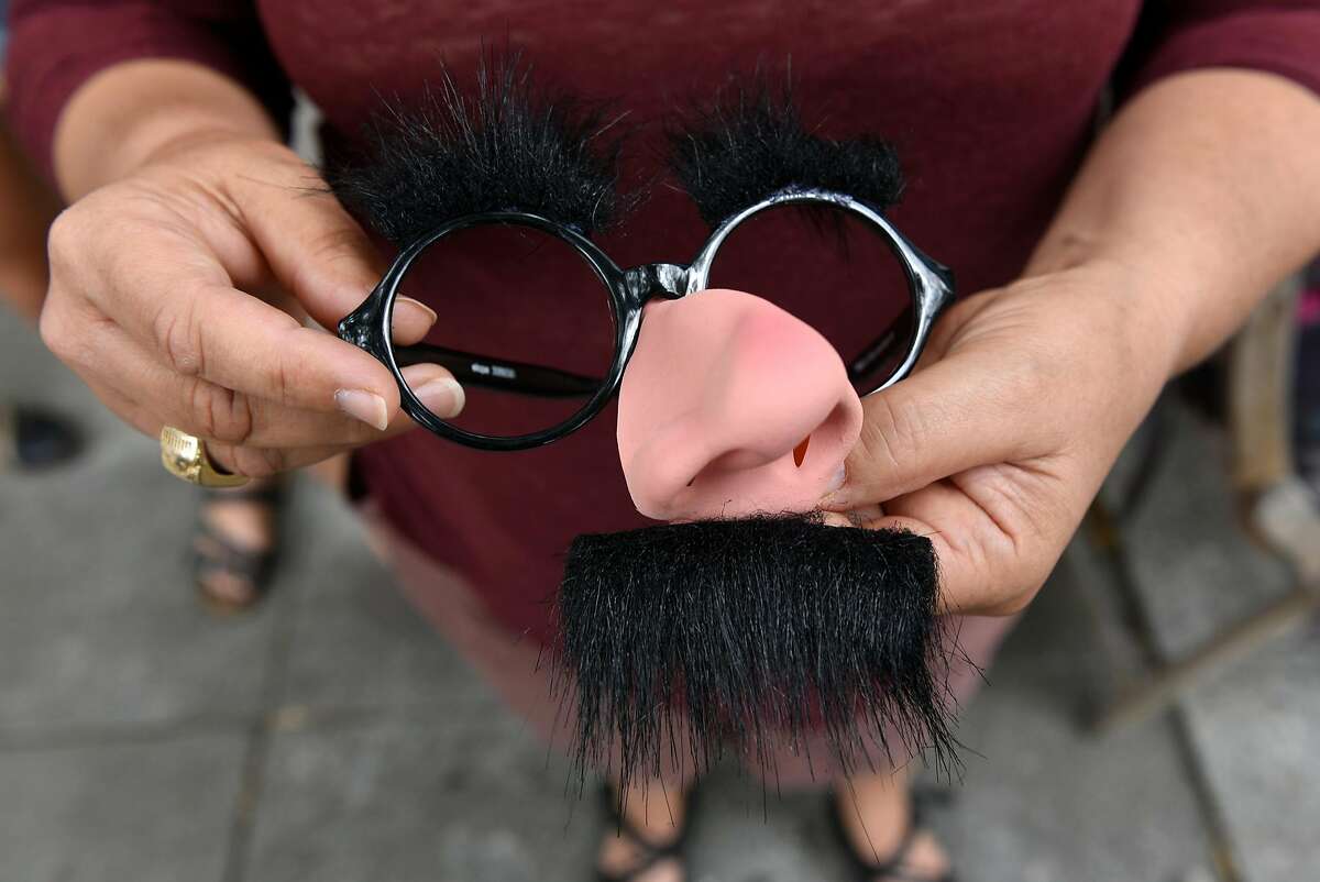 Isobel White holds her Groucho Marx disguise after purchasing them at Mr. Mopps' Toy Shop in Berkeley, CA, on Wednesday August 23, 2017. Isobel and friends plan on wearing the Groucho Marx glasses and mustaches while counter protesting at the upcoming right wing �No to Marxism� rally in Berkeley.