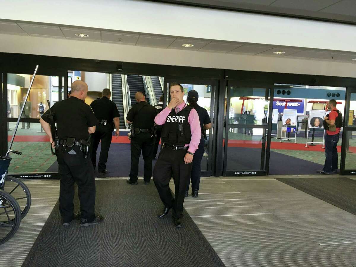 Police officers gather at a terminal at Bishop International Airport, Wednesday morning, June 21, 2017, in Flint, Mich. Officials evacuated the airport Wednesday, where a witness said he saw an officer bleeding from his neck and a knife nearby on the ground. On Twitter, Michigan State Police say the officer is in critical condition and the FBI was leading the investigation.