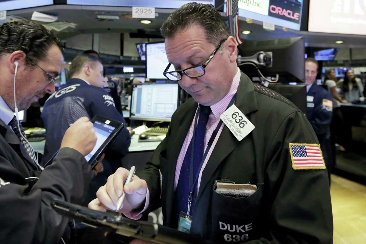 Trader Edward Curran, right, works on the floor of the New York Stock Exchange Tuesday.