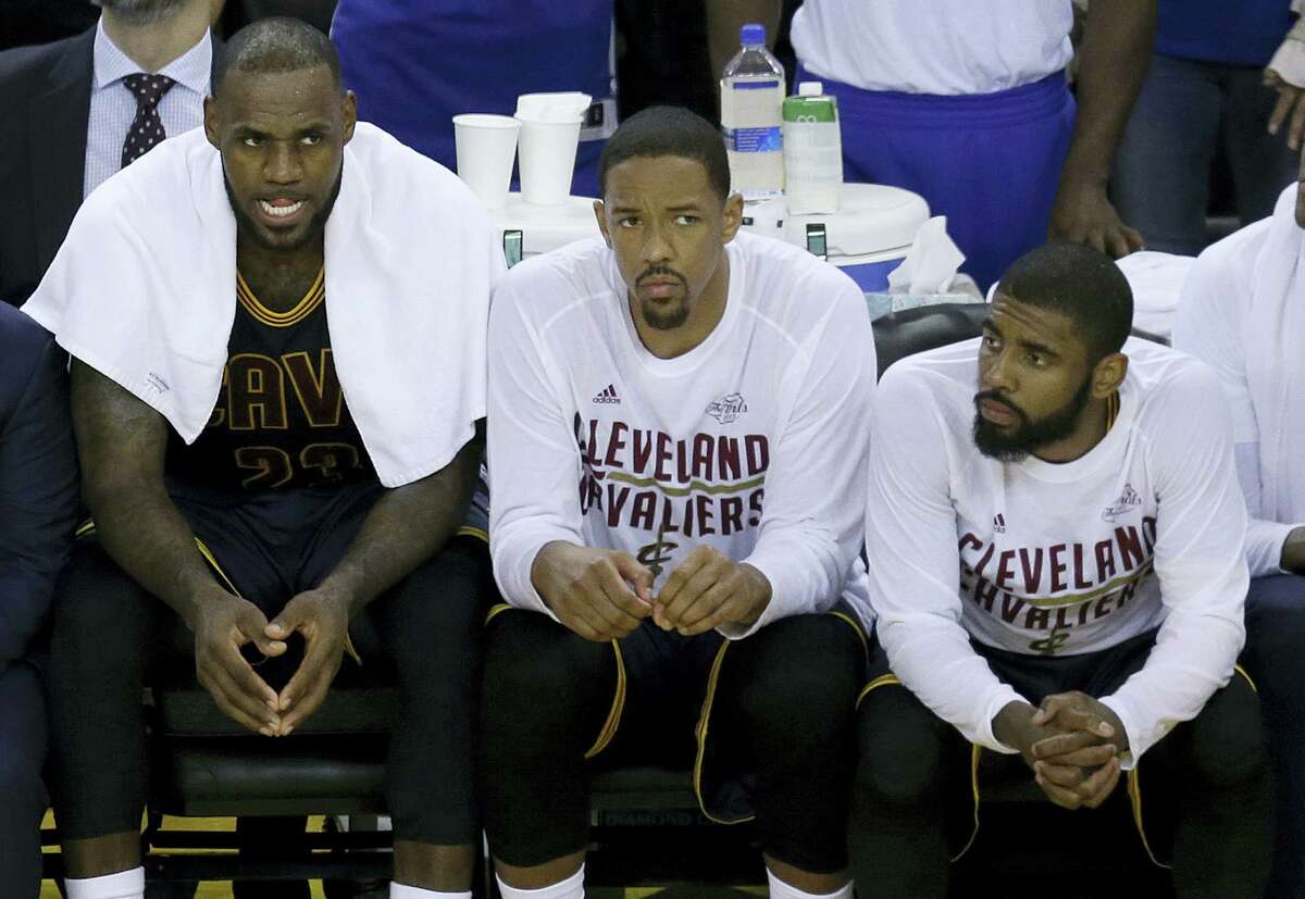 Cleveland Cavaliers forward LeBron James, from left, sits on the bench with center Tristan Thompson and guard Kyrie Irving during the second half of Game 1 of the NBA Finals against the Golden State Warriors in Oakland Thursday.