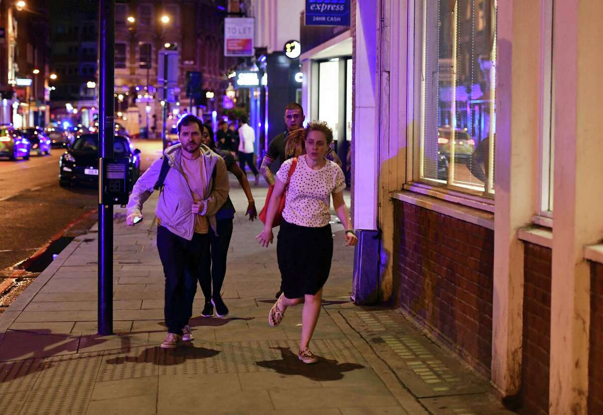 People run down Borough High Street as police are dealing with a “major incident” at London Bridge in London, Saturday, June 3, 2017.