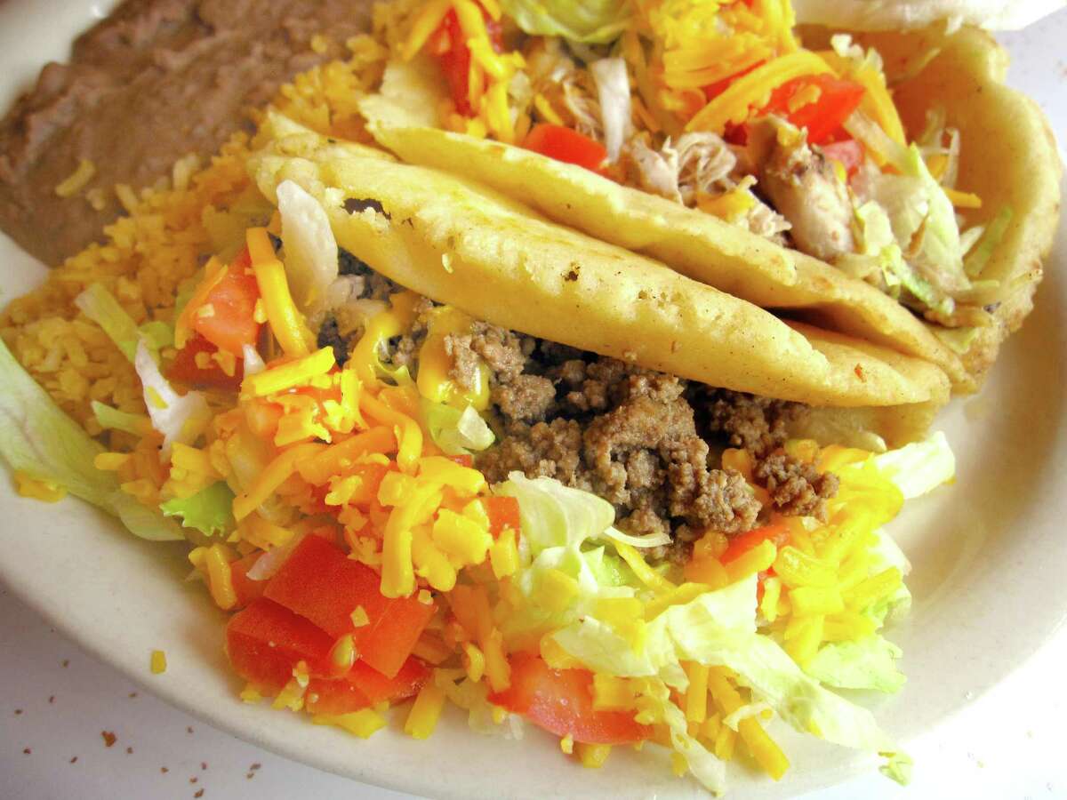 Puffy taco platter with rice and beans and two puffy tacos (beef picadillo, foreground, and chicken) from Yolanda's Uptown Cafe.