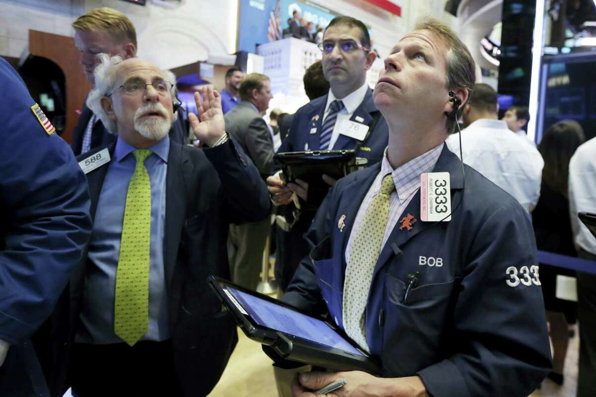 Traders Peter Tuchman, left, and Robert Charmak, right, work on the floor of the New York Stock Exchange Wednesday.