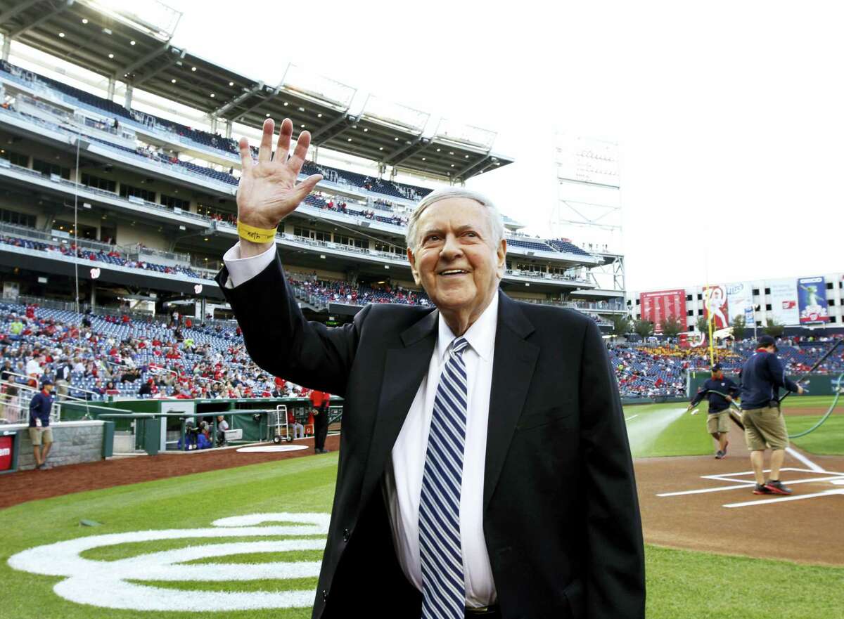 FILE - In this Friday, April 26, 2013 file photo, former Washington Senators broadcaster Bob Wolff waves to the crowd during a pre-game ceremony to honor him, before a baseball game between the Washington Nationals and the Cincinnati Reds at Nationals Park in Washington. Bob Wolff, the only sportscaster to call play-by-play of championships in all four major North American professional team sports, has died, Saturday, July 15, 2017. He was 96. (AP Photo/Alex Brandon, File)