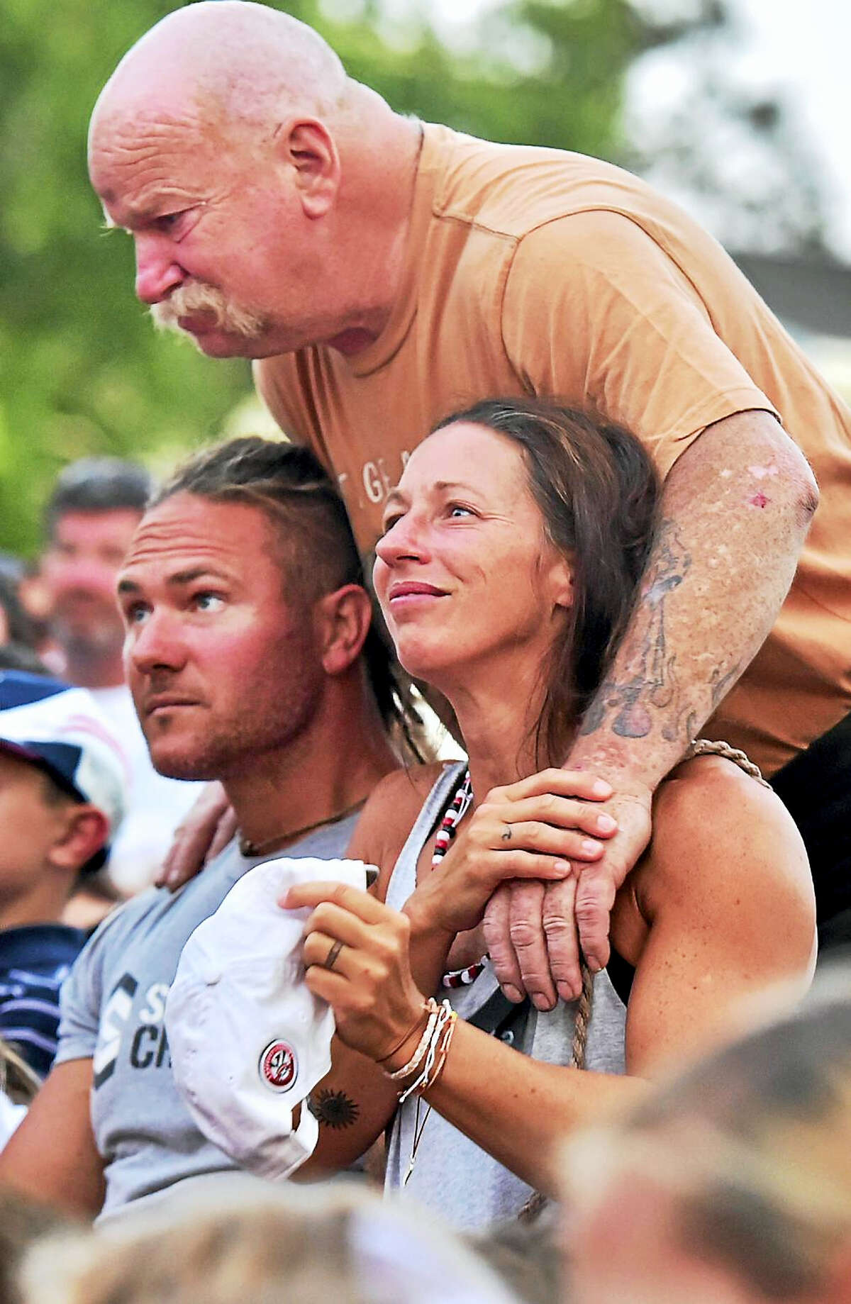 (Peter Hvizdak - Hearst Connecticut Media) Dave and Paula Callahan, the parents of drowning victim Ben Callahan, 10, of Branford, are hugged by friend William “Bones” Burkhardt of Madison during a candlelight vigil for Ben on the Branford Green.
