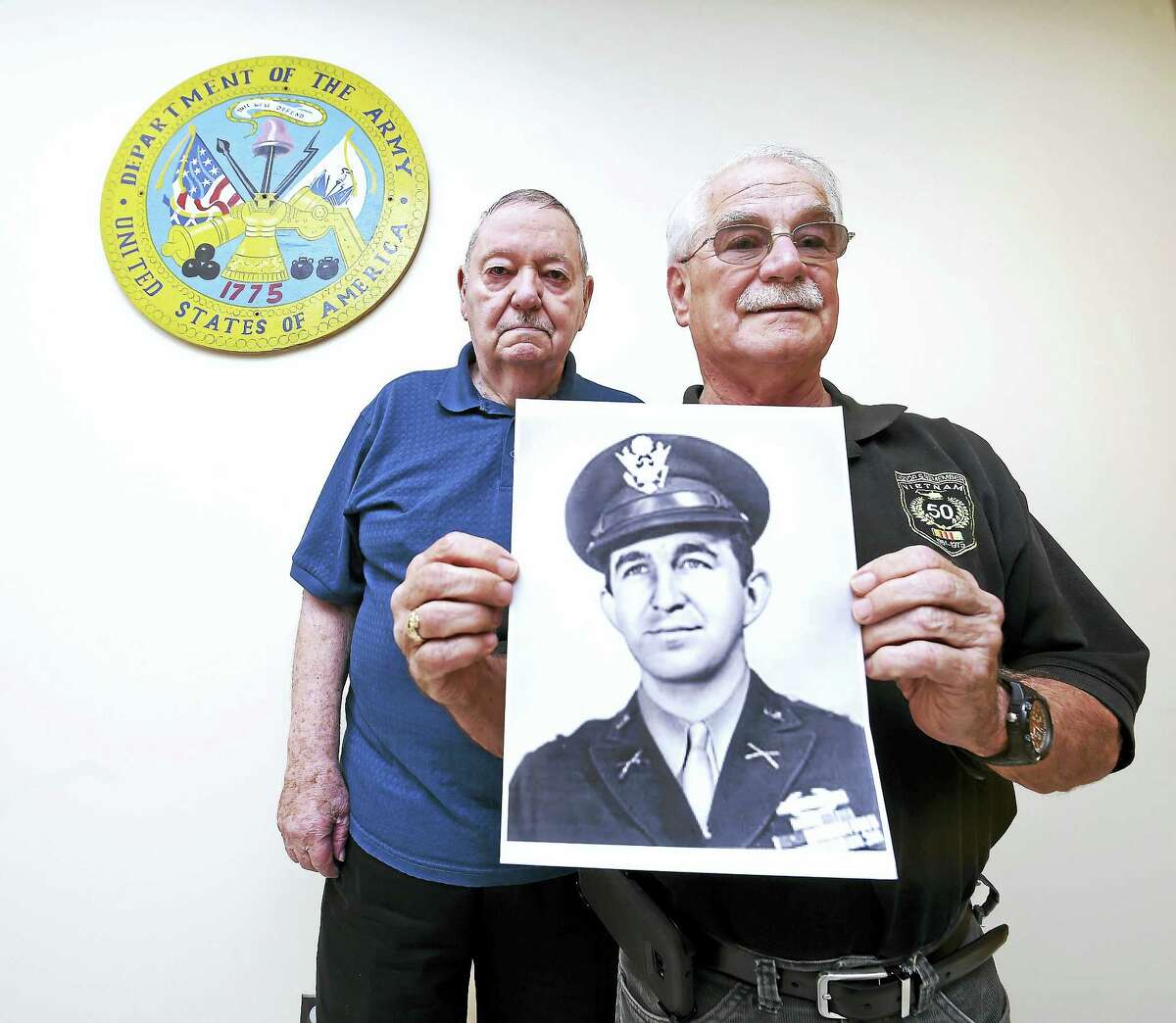 Frank Carrano (left) of East Haven and Daniel McHale of Avon are pictured with a photograph of Robert Nett from his days as a captain in the U.S. Army during World War II.
