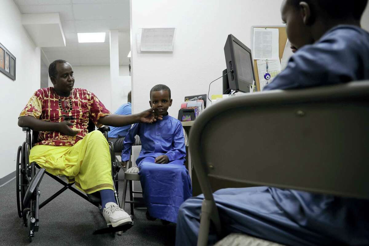 Ali Said, of Somalia, left, waits at a center for refugees with his two sons Thursday, July 6, 2017, in San Diego. Said, whose leg was blown off by a grenade, says he feels unbelievably lucky to be among the last refugees allowed into the United States before stricter rules kick in as part of the Trump administration’s travel ban.