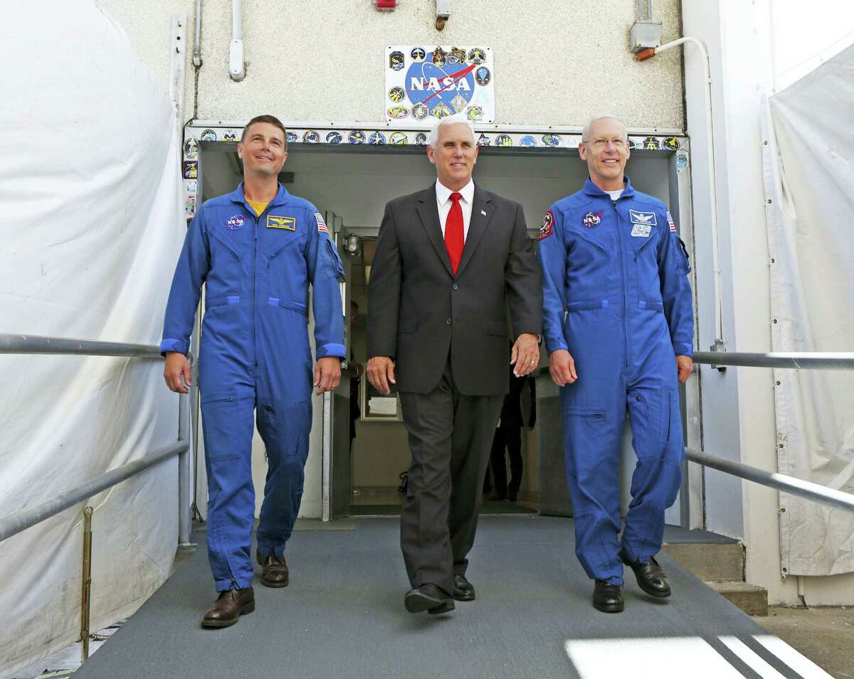 Vice President Mike Pence, center, is flanked by NASA astronaut Reid Wiseman, left, and Patrick Forrester, NASA Chief astronaut as they walk out of crew headquarters at the Kennedy Space Center in Cape Canaveral, Fla., on Thursday, July 6, 2017. Pence is leading a newly revived National Space Council.