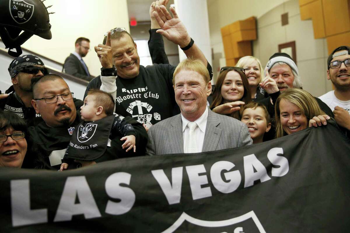 Oakland Raiders owner Mark Davis, center, meets with Raiders fans after speaking at a meeting of the Southern Nevada Tourism Infrastructure Committee, in Las Vegas.