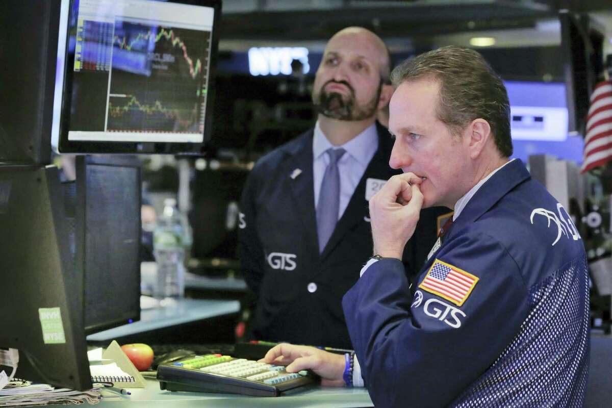 Specialists Glenn Carell, right, and James Denaro work on the floor of the New York Stock Exchange Monday.