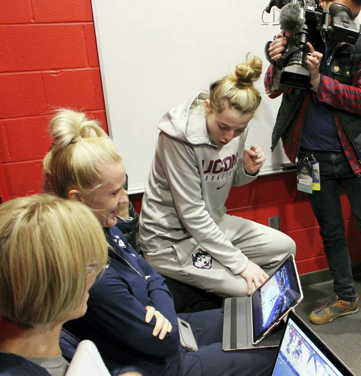 UConn’s Katie Lou Samuelson watches a computer in the team’s locker room in Bridgeport as her sister Karlie’s Stanford team takes on Notre Dame in the Lexington regional on Sunday.