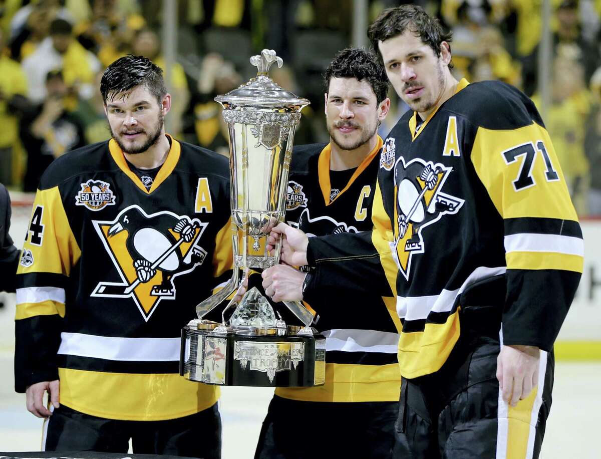 Sidney Crosby, center, holds the Prince of Wales Trophy and poses with assistant captains Evgeni Malkin (71) and Chris Kunitz after beating the Senators in Game 7 of the Eastern Conference finals.