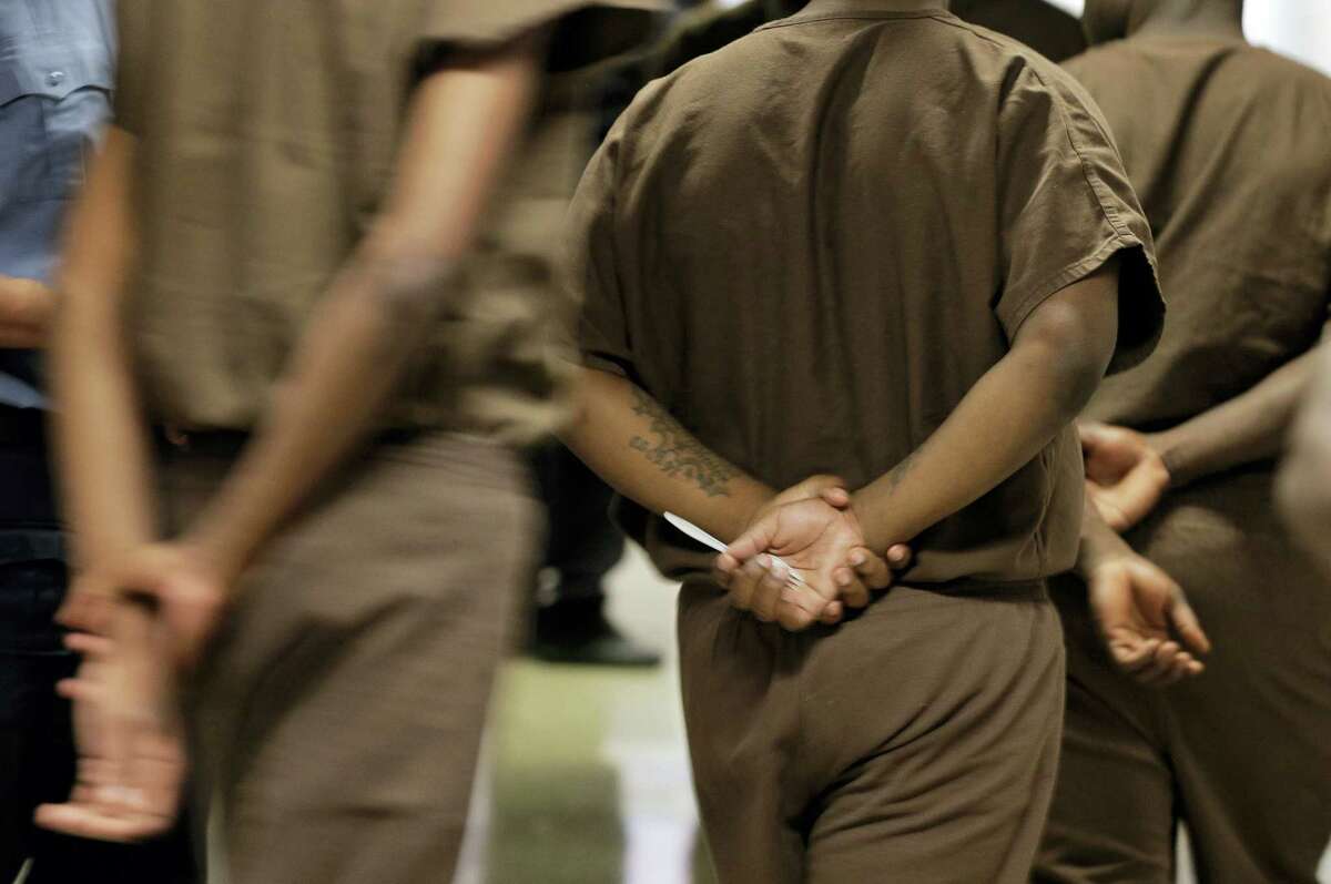 In this file photo, juvenile detention inmates at New York’s Rikers Island jail walk in a single file to the chapel. Some activists say shutting down Rikers is the only solution for a cycle of abuses that includes violence by guards and gang members, mistreatment of the mentally ill and juveniles, and unjustly long detention for minor offenders.