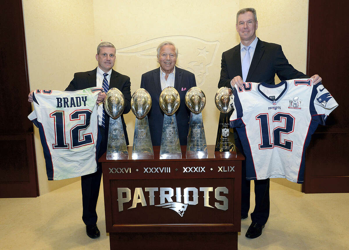 In this photo released by the Federal Bureau of Investigation, Harold H. Shaw, left, Special Agent in Charge of the FBI Boston Division and Colonel Richard D. McKeon, right, of the Massachusetts State Police, hold two recovered Super Bowl jerseys worn by New England Patriots quarterback Tom Brady, beside team owner Robert Kraft, center, on Thursday in the team’s trophy room at Gillette Stadium.