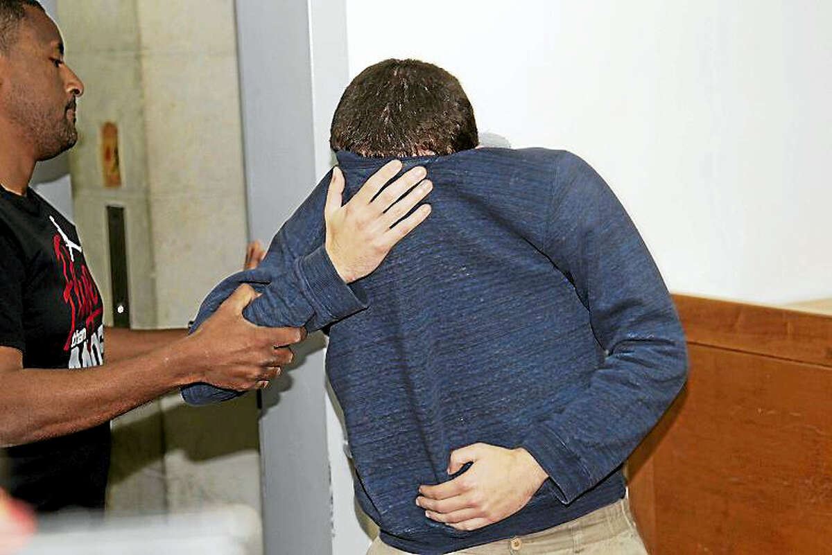 A 19-year-old dual U.S.-Israeli citizen covers his face as he is brought to court in Rishon Lezion, Israel, Thursday, March 23, 2017. Israeli police said they have arrested a Jewish Israeli man who is the prime suspect behind a wave of bomb threats against Jewish community centers and other institutions in the United States. The police withheld his identity.