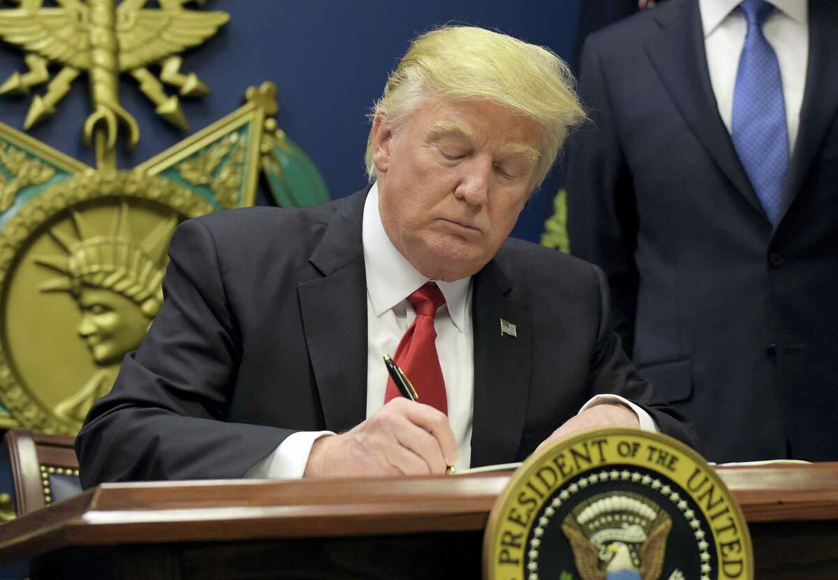 President Donald Trump signs an executive order on extreme vetting during an event at the Pentagon in Washington Friday.