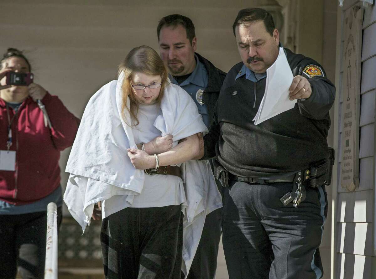 In this Jan. 8, 2017, file photo, Sara Packer, center, handcuffed, the adoptive mother of Grace Packer, is led out of District Court in Newtown, Pa., by Pennsylvania Constables and taken into custody. Packer, whose teenage daughter’s dismembered remains were found in the woods last fall, has been charged along with her boyfriend Jacob Sullivan with killing the girl in a “rape-murder fantasy” the couple shared, a prosecutor said.