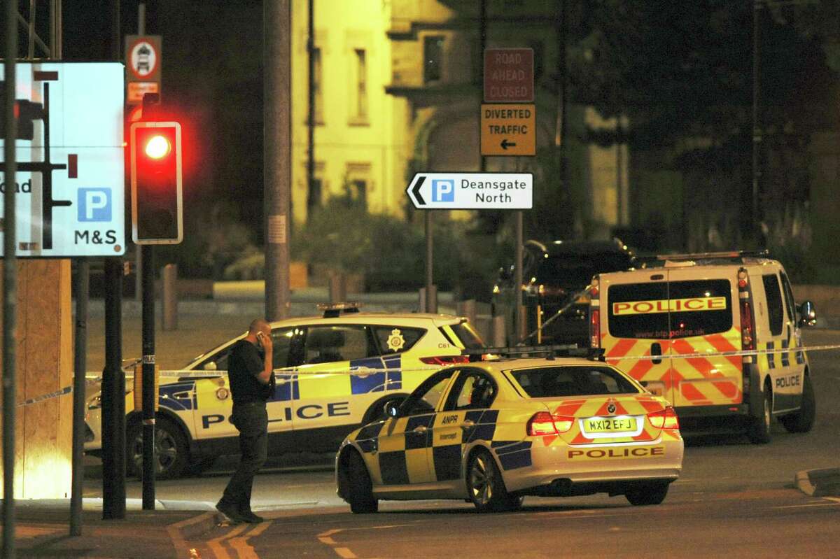 Armed police block a road near to the Manchester Arena in central Manchester, England, Tuesday. An explosion struck an Ariana Grande concert in northern England late Monday, killing over a dozen people and injuring dozens in what police say they are treating as a terrorist attack.
