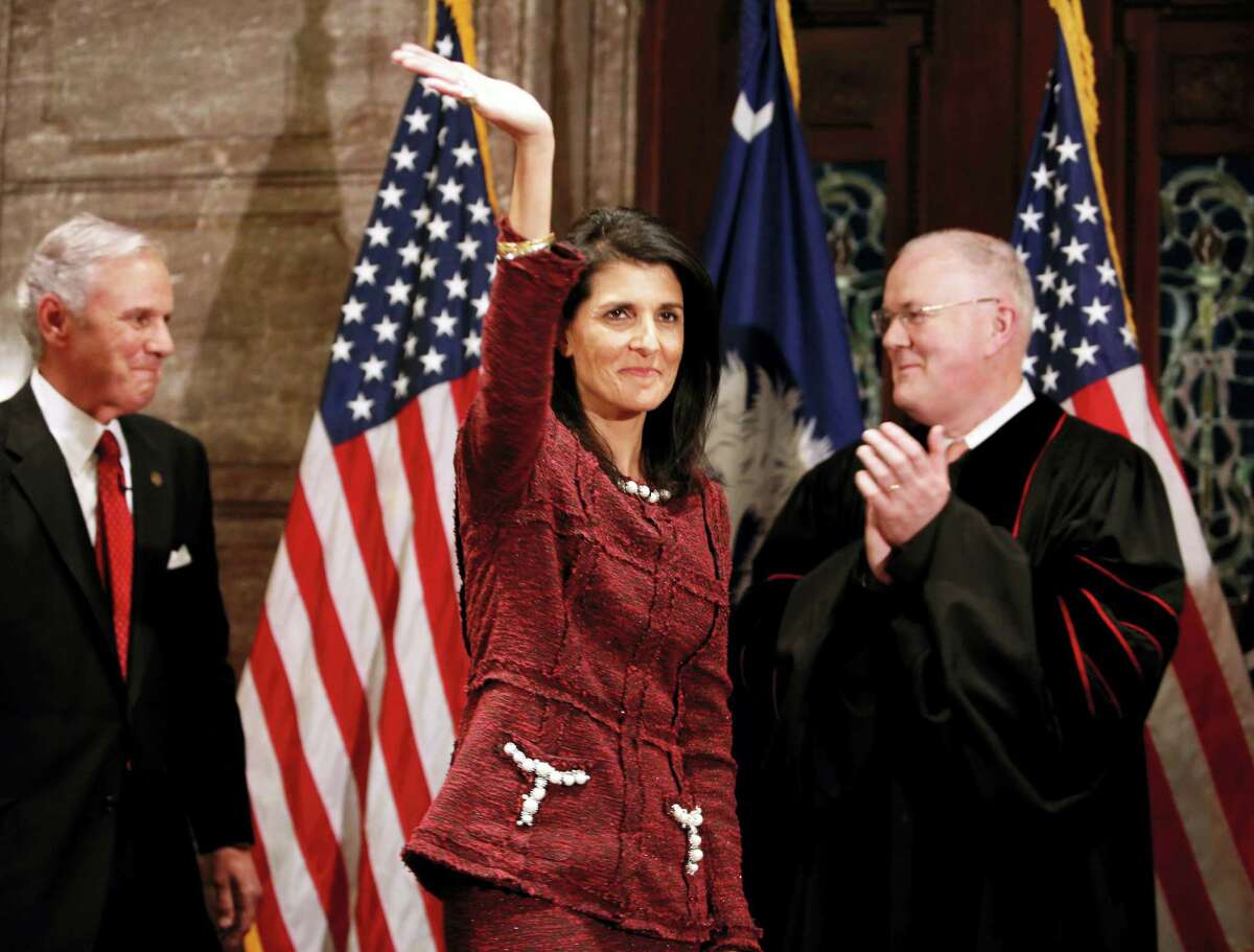 Former South Carolina Governor and current ambassador to the United Nations, Nikki Haley, in middle, waves to the crowd after current Governor Henry McMaster, at left, was sworn in by S.C. Chief Justice Don Beatty during a ceremonial swearing in at the Statehouse Tuesday in Columbia, S.C. Haley resigned as governor after she became ambassador to the United Nations.