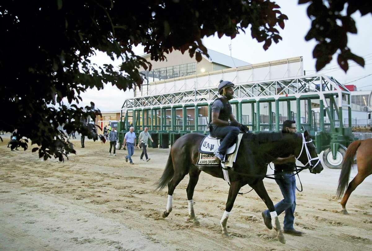 Kentucky Derby winner Always Dreaming, ridden by exercise rider Nick Bush, walks past the starting gates at Pimlico Race Course in Baltimore.
